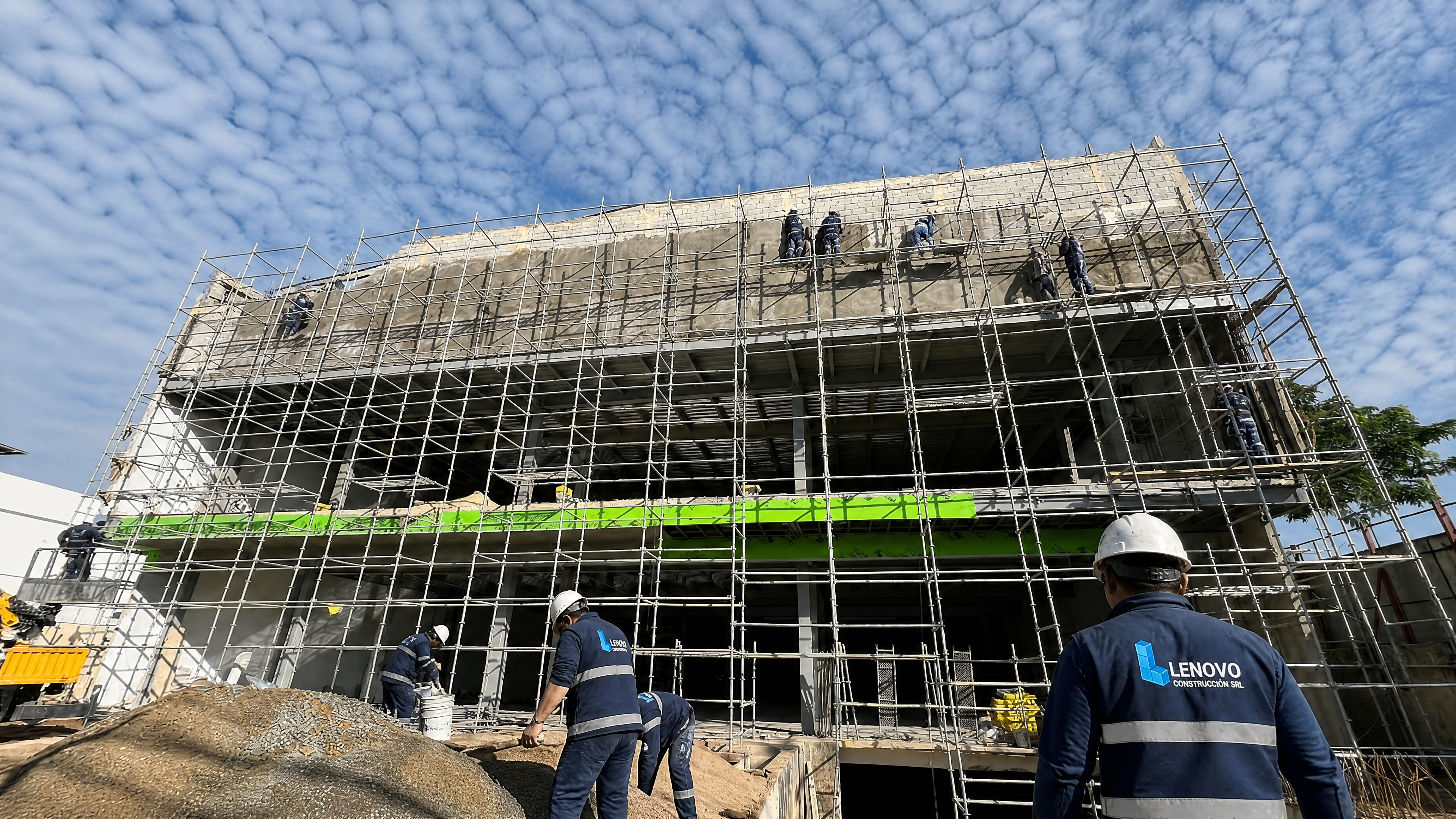 Equipo de Lenovo Construcción trabajando en obra: edificio en construcción con andamios