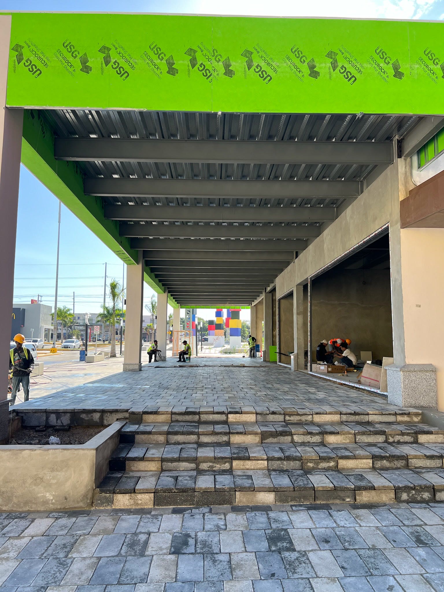 Galería comercial durante la construcción, con losa pintada y personal en obra