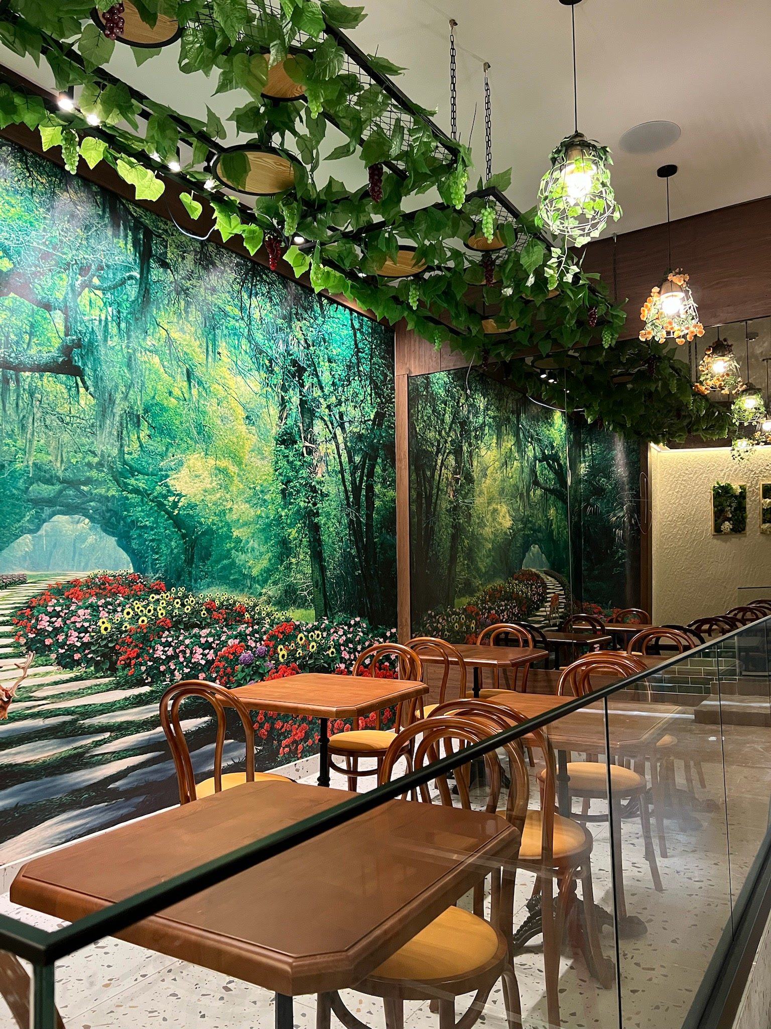 Comedor con mural de bosque y follaje colgante
