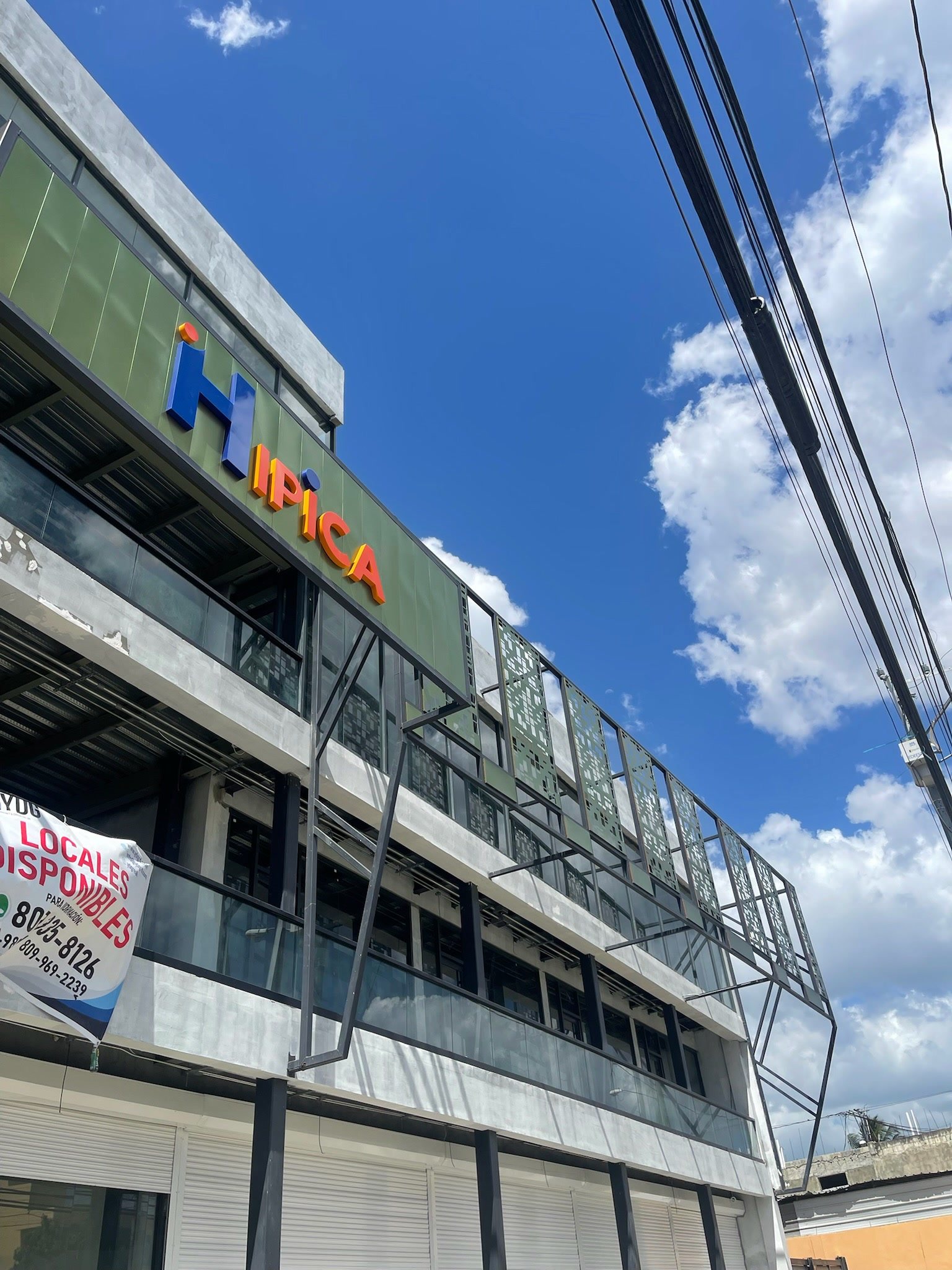 Fachada de la plaza comercial terminada con letrero corporativo