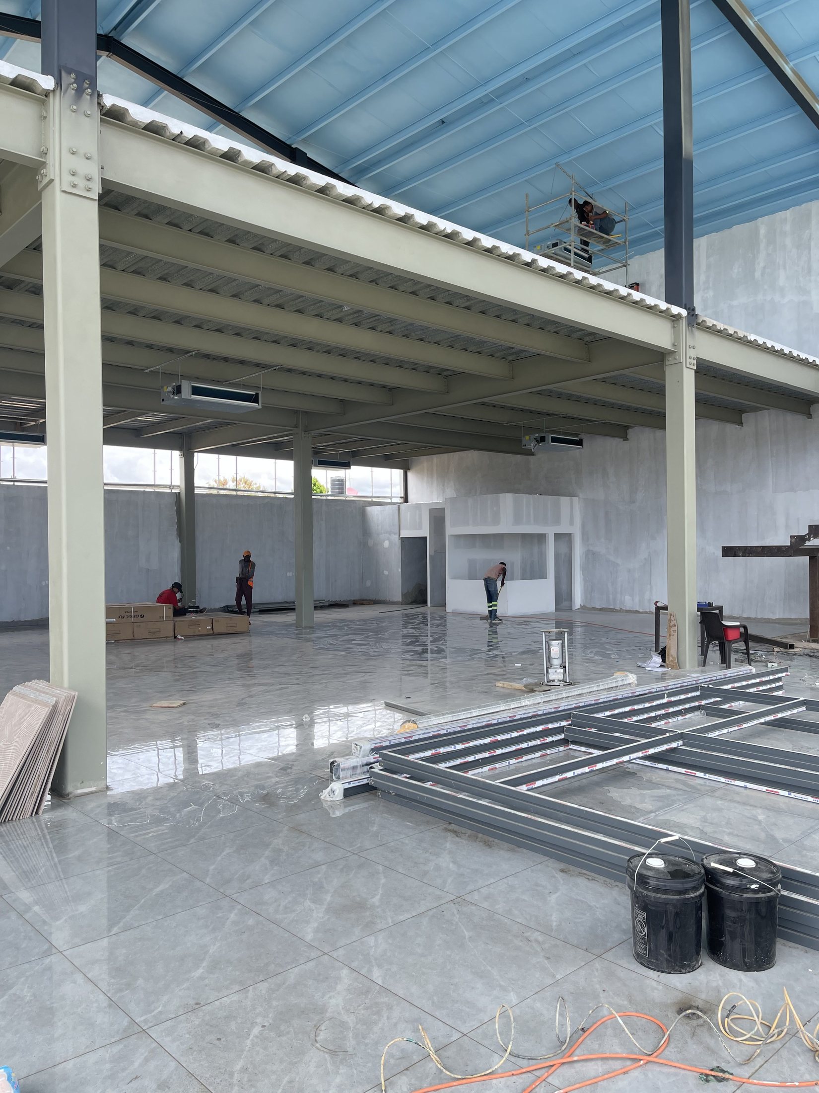 Salón de exhibición con piso pulido y estructura metálica