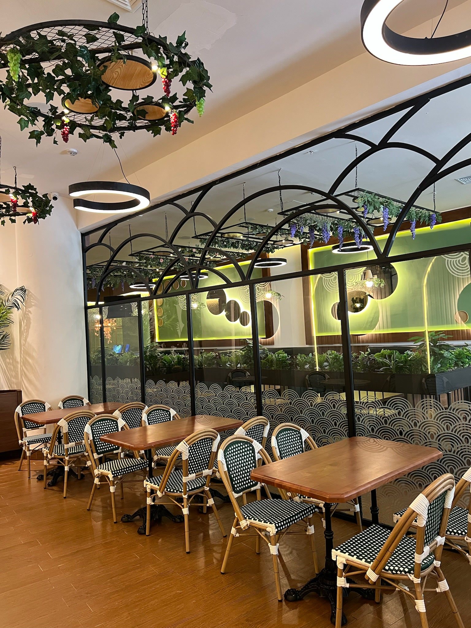 Terraza cubierta con estructura metálica arqueada y sillería de ratán