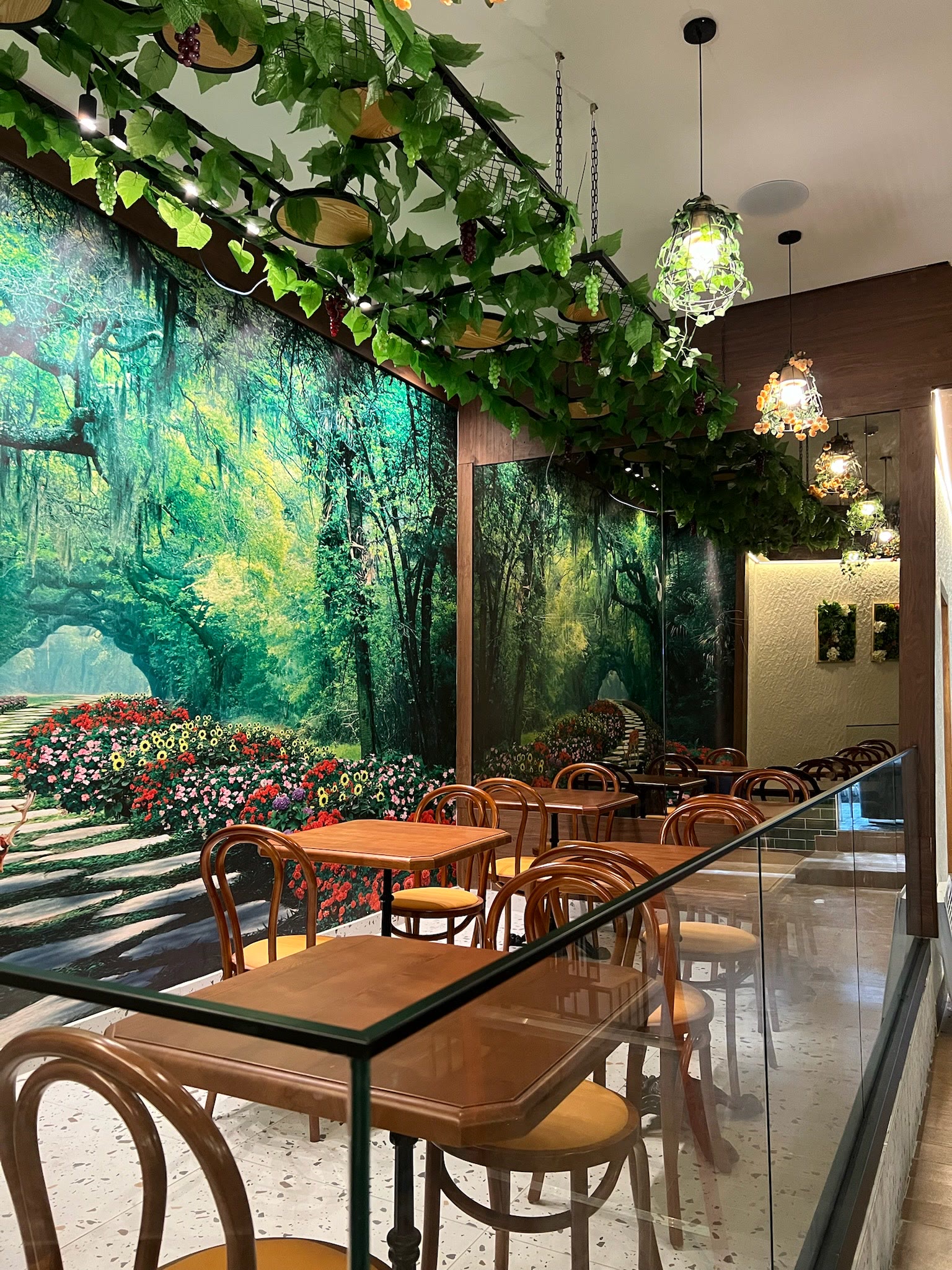 Comedor con mural de bosque y follaje colgante