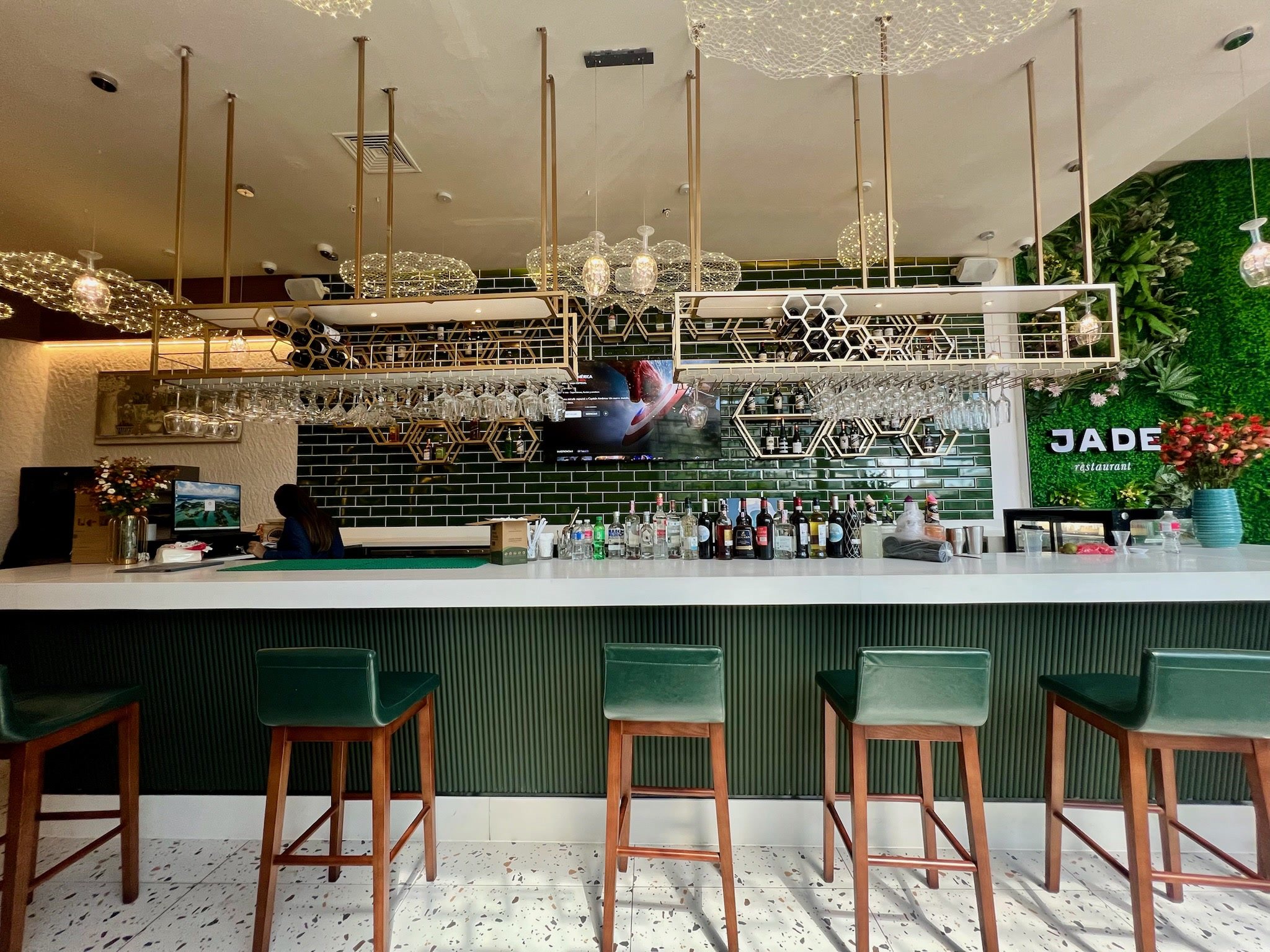 Barra del restaurante con azulejo verde y banquetas altas